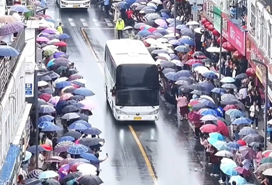 毛坦厂中学再现万人雨中送考  首辆送考大巴车牌“91666”